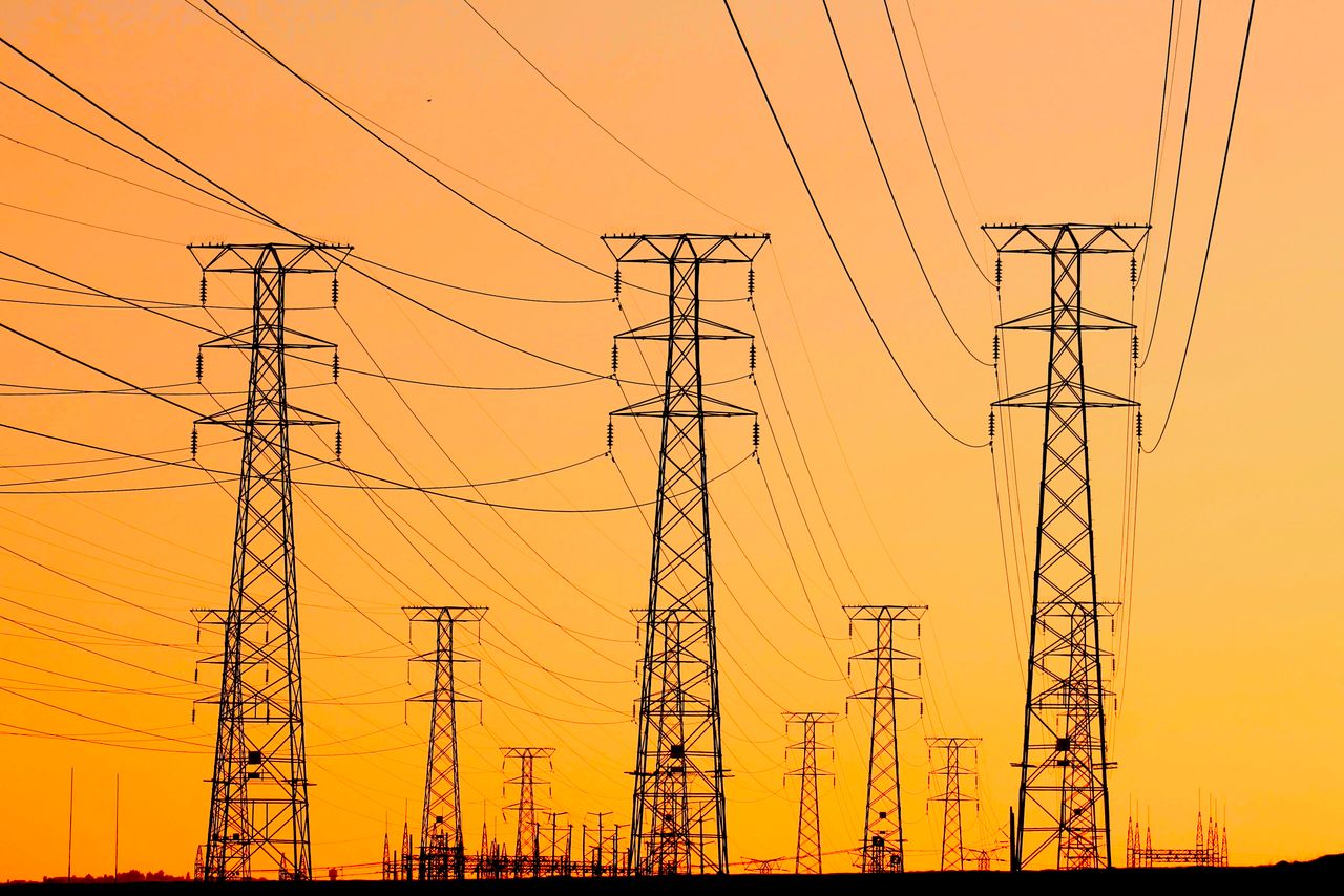 Crafting Captivating Headlines: Your awesome post title goes here Silhouetted power lines against a vibrant orange sunset, symbolizing energy and infrastructure.